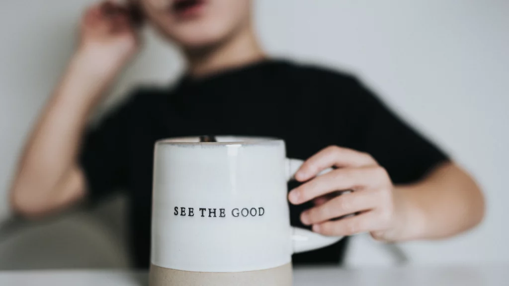 Kind hält Tasse mit der Aufschrift "see the good"